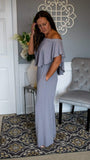 Elastic Off Shoulder Flounce Bodice Jumpsuit 5/28 - Fate & Co. Look sophisticated as ever when you slip on this classy, chic and incredibly comfortable jumpsuit. This silver jumpsuit features an elastic off the shoulder top, full flounce bodice, elastic waist, pockets and wide leg bottom. This jumpsuit feels like butter on your body and can be dressed up or down depending on the occasion. We love it with a pair of sleek heels and stacked bracelets to complete your look.   95% Polyester 5% Spandex