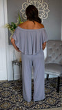 Elastic Off Shoulder Flounce Bodice Jumpsuit 5/28 - Fate & Co. Look sophisticated as ever when you slip on this classy, chic and incredibly comfortable jumpsuit. This silver jumpsuit features an elastic off the shoulder top, full flounce bodice, elastic waist, pockets and wide leg bottom. This jumpsuit feels like butter on your body and can be dressed up or down depending on the occasion. We love it with a pair of sleek heels and stacked bracelets to complete your look.   95% Polyester 5% Spandex