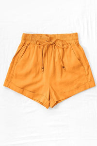 Linen Type Waistband Shorts with String Tie - Mango - Fate & Co. There is nothing better than a pair of linen shorts to throw on in the summer. Our Daydream Linen shorts feature a relaxed fit, pull on elastic waistband, adjustable string tie and are available in multiple colors! Pair with a classic white tank or tee for an effortless summer look!  Color: Mango  55% Linen 45% Viscose