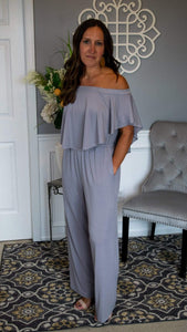 Elastic Off Shoulder Flounce Bodice Jumpsuit 5/28 - Fate & Co.Look sophisticated as ever when you slip on this classy, chic and incredibly comfortable jumpsuit. This silver jumpsuit features an elastic off the shoulder top, full flounce bodice, elastic waist, pockets and wide leg bottom. This jumpsuit feels like butter on your body and can be dressed up or down depending on the occasion. We love it with a pair of sleek heels and stacked bracelets to complete your look.   95% Polyester 5% Spandex