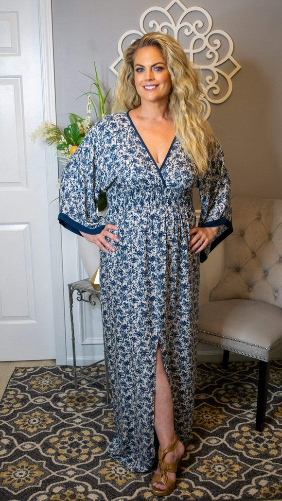 This stunning boho/kimono inspired maxi dress is the perfect choice for your upcoming summer event season. Featuring an all over floral print, v-neck, smocked waist, front slit and kimono sleeve with contrast trim detail, this maxi dress is sure to turn heads at your next event! Pair this dress with a simple flat sandal or pump it up with a wedge or heel! Either way, this dress provides chic elegance with a twist! 