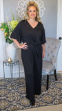 This classic black jumpsuit was made for a night on the town or a girls day out! Featuring a v neckline, keyhole back and a very flattering tie waistline, this bell sleeve jumpsuit is a quick and easy way to look on trend and be comfortable doing it!  Made in USA  Solid Rayon Spandex  Available in sizes: S, M, L, XL 