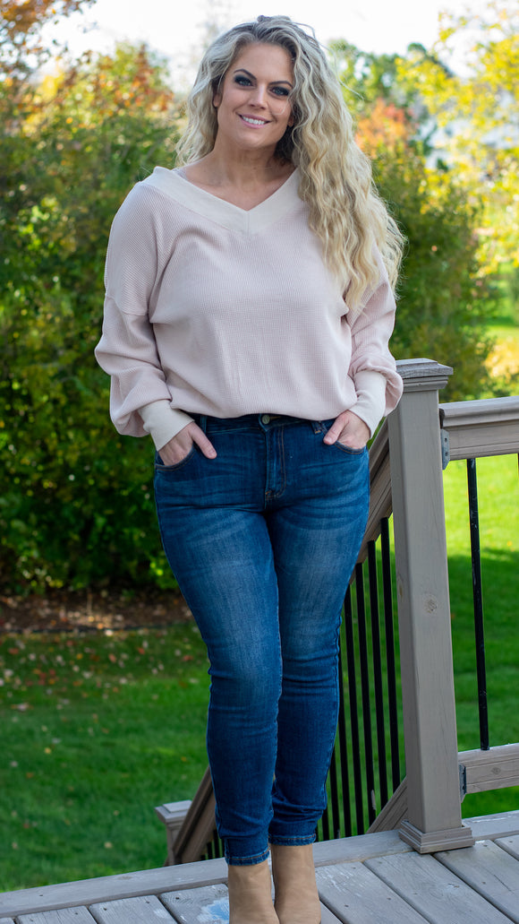 A perfect all-season blouse, treat yourself to this elegant on or off-shoulder waffle knit pullover top. Featuring a soft and stunning apricot color, v-neckline, a long tapered dolman sleeve and fitted hem. This versatile top will take you from day to night with ease! Pair it with jeans and booties for a casual vibe, or with a skirt and pumps for a flirty date night look.  Color: Apricot