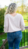 A perfect all-season blouse, treat yourself to this elegant on or off-shoulder waffle knit pullover top. Featuring a soft and stunning apricot color, v-neckline, a long tapered dolman sleeve and fitted hem. This versatile top will take you from day to night with ease! Pair it with jeans and booties for a casual vibe, or with a skirt and pumps for a flirty date night look.  Color: Apricot